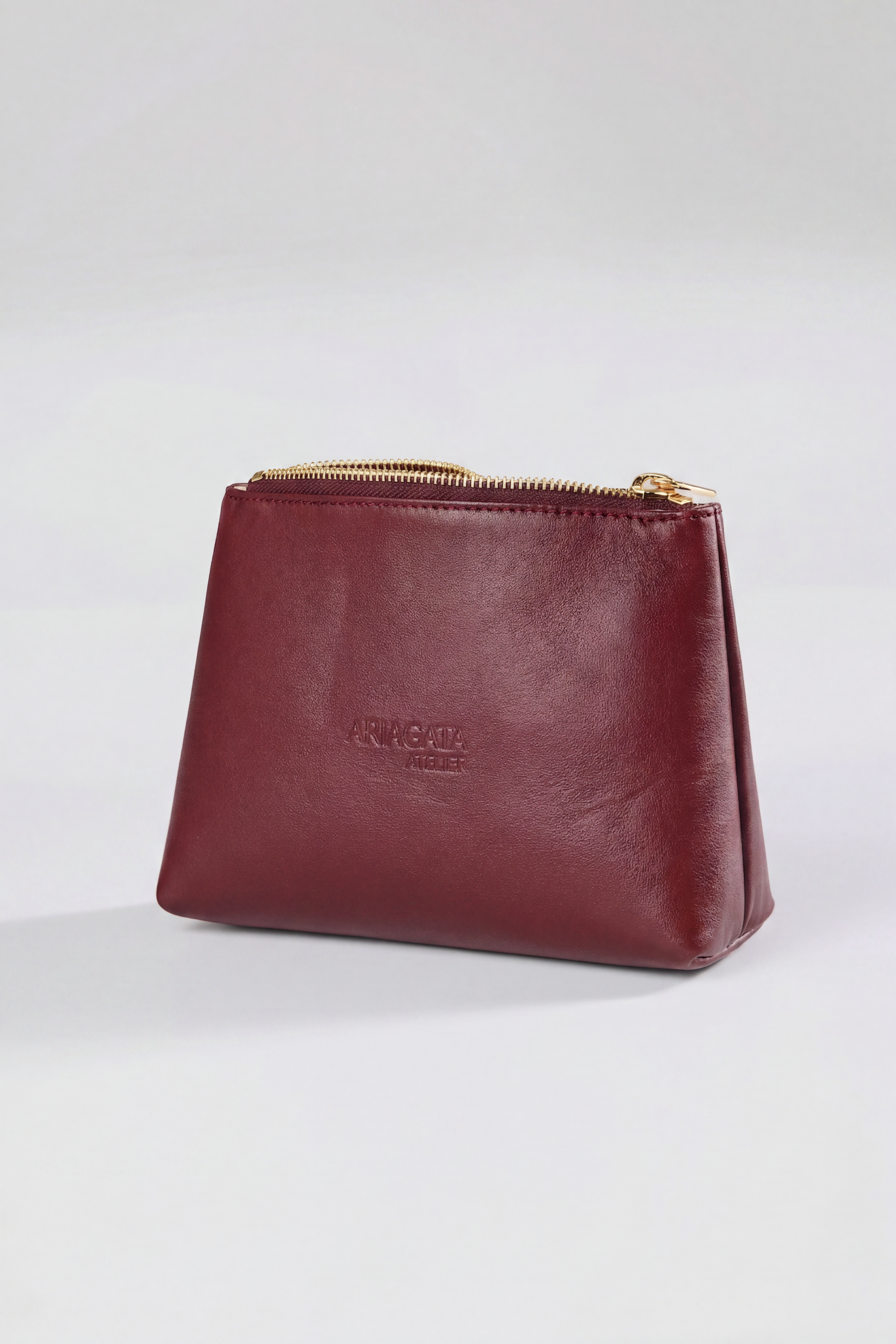 Ariagata cosmetic bag in deep bordeaux red leather, front view